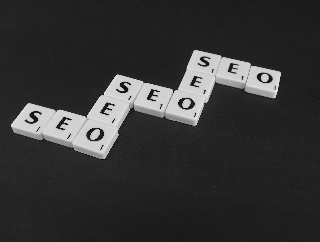digital SEO spelled with Scrabble tiles on a black surface, representing search engine optimization concepts.